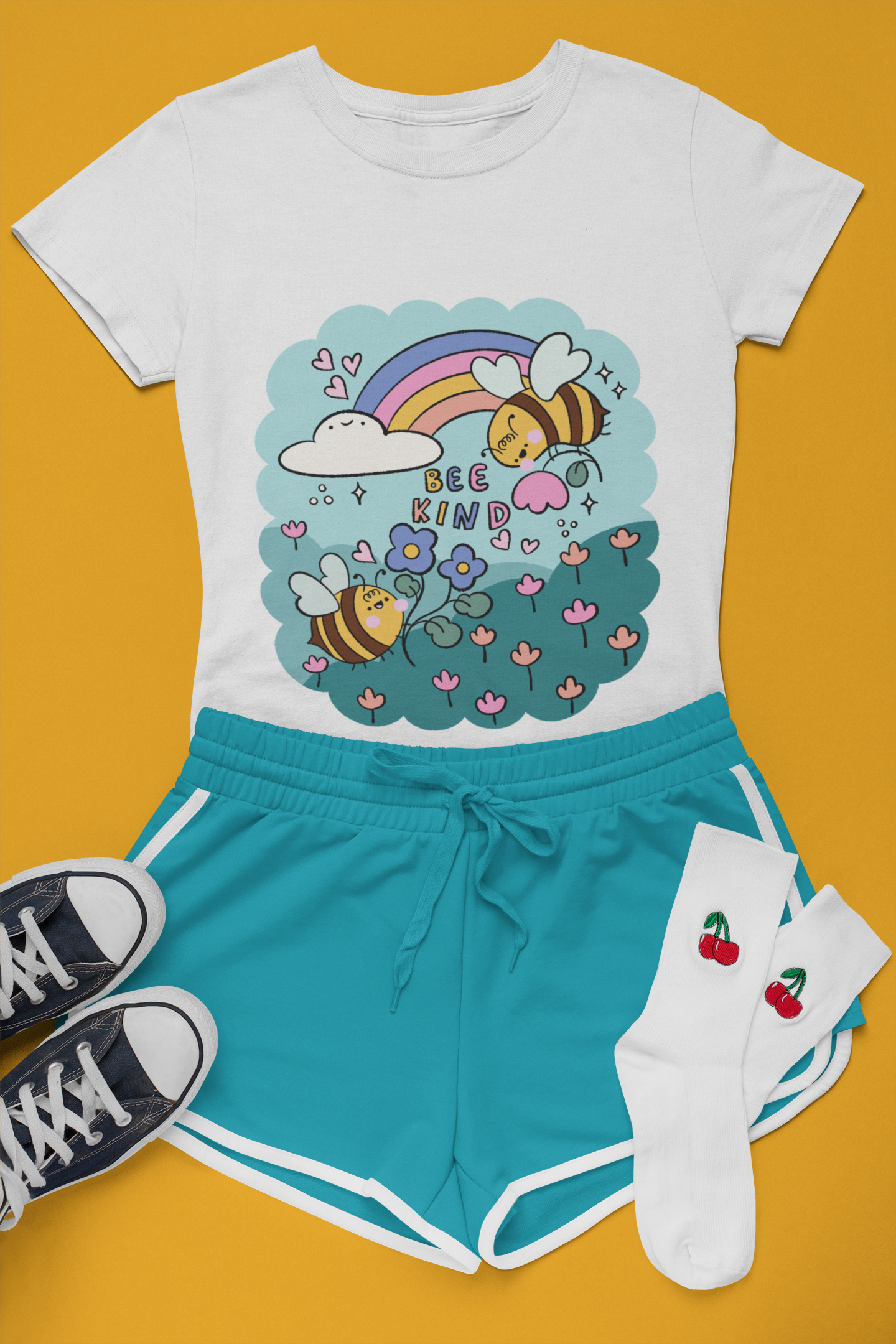 A styled flatlay of a t-shirt with a print of two bees in a field of flowers.